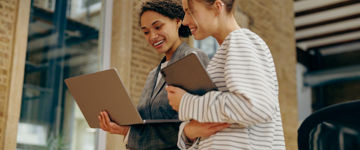Two business woman work together to get the job done at the office and use laptop Two business woman work together to get the job done at the office and use laptop